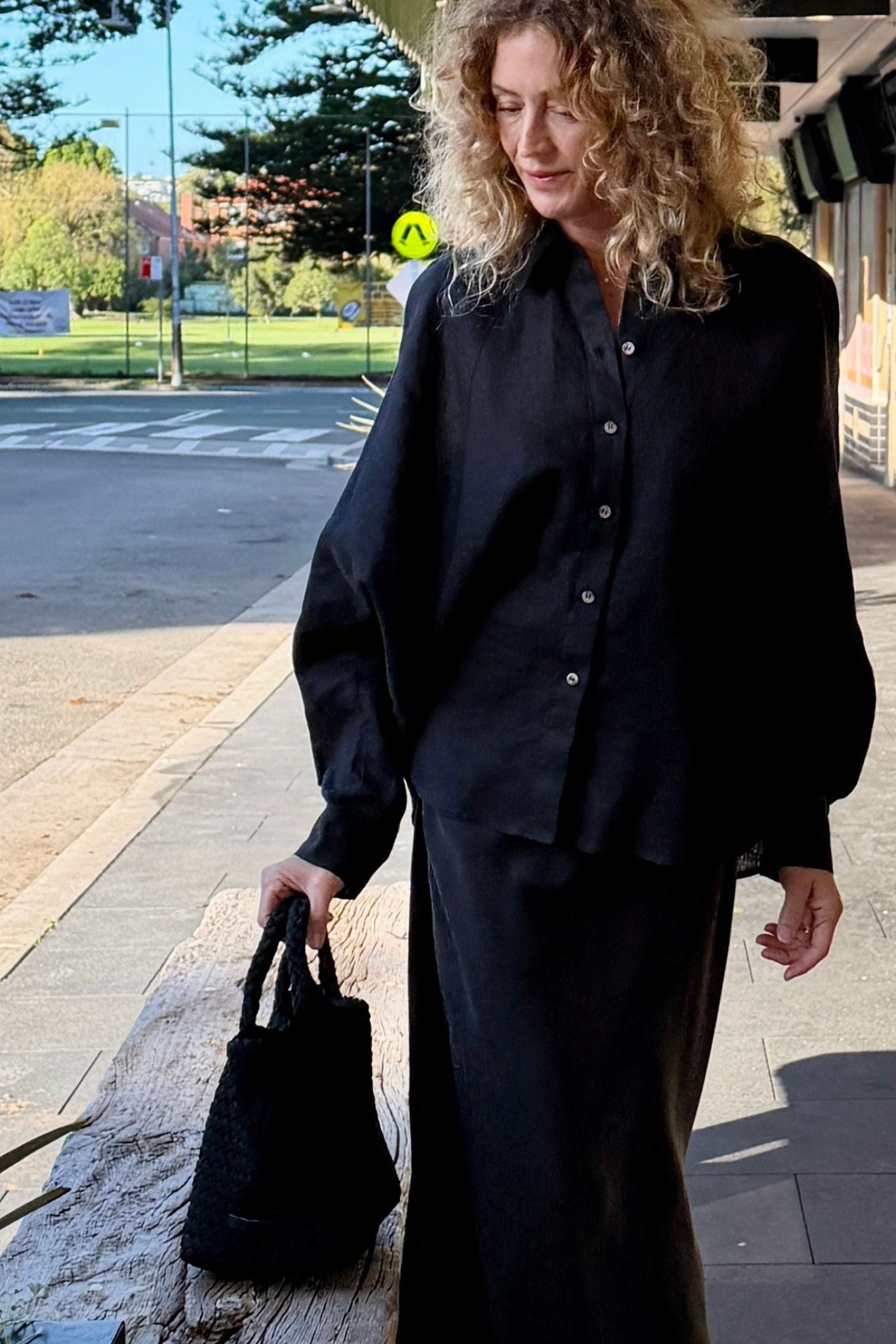 Woman wearing the Eira black linen shirt by Twill & Tee