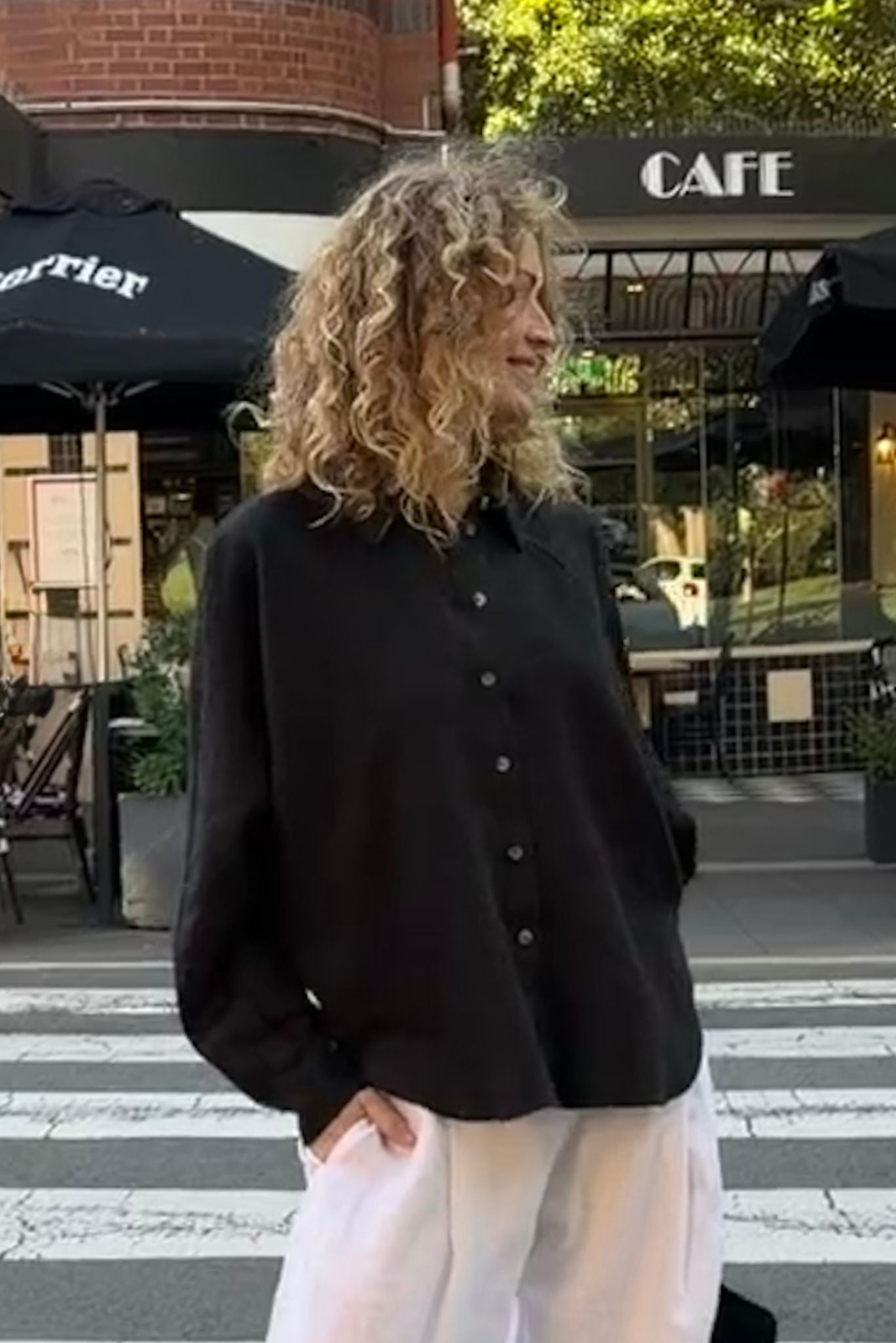 Eira black linen shirt with relaxed silhouette and curved hem.